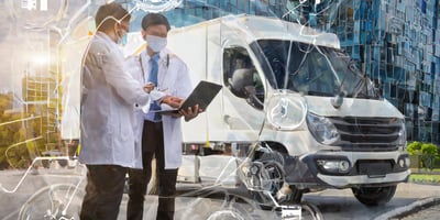 two people looking at a clipboard in front of their fleet vehicle
